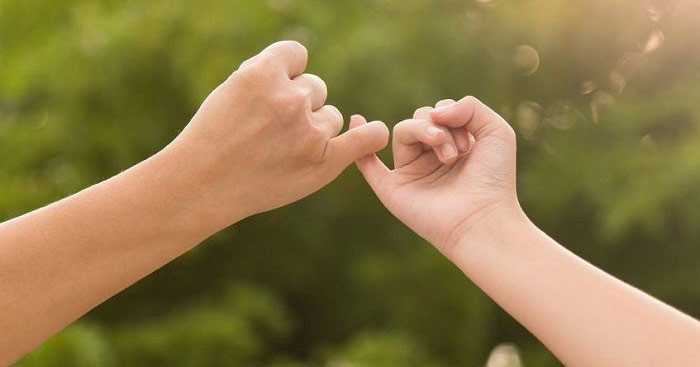 Đôi tay đang hứa hẹn với nhau, thể hiện sự tin tưởng và cam kết giữa hai người