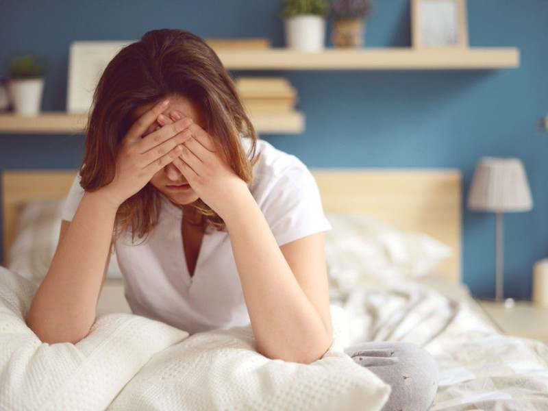 Người phụ nữ ôm mặt khóc, thể hiện sự căng thẳng và áp lực trong gia đình, gợi ý về gánh nặng tâm lý mà các thành viên phải đối mặt.