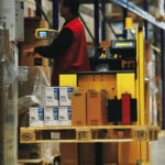 Người vận hành xe nâng order picker trong kho hàng, thao tác chọn hàng từ kệ