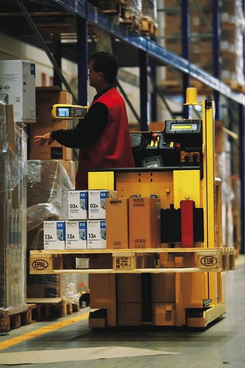 Người vận hành xe nâng order picker trong kho hàng, thao tác chọn hàng từ kệ